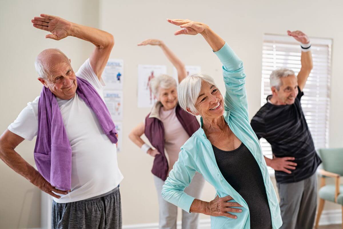 The image of seniors stretching together at the gym which means to opt for low-cost fitness programs for seniors that promotes health and savings together.