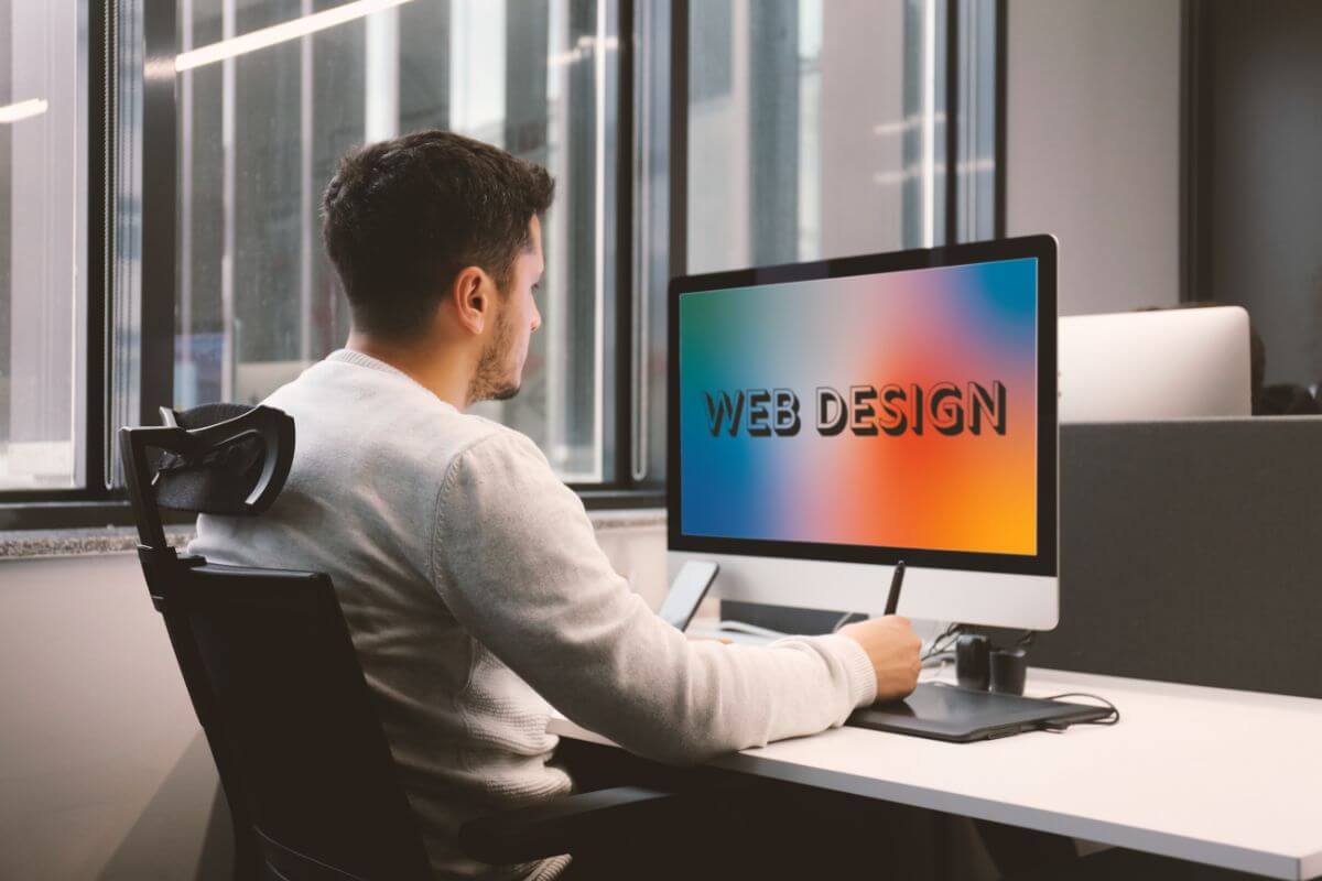 The photo shows a using a computer desk at home referring to offering web design services to turn creativity into income. 