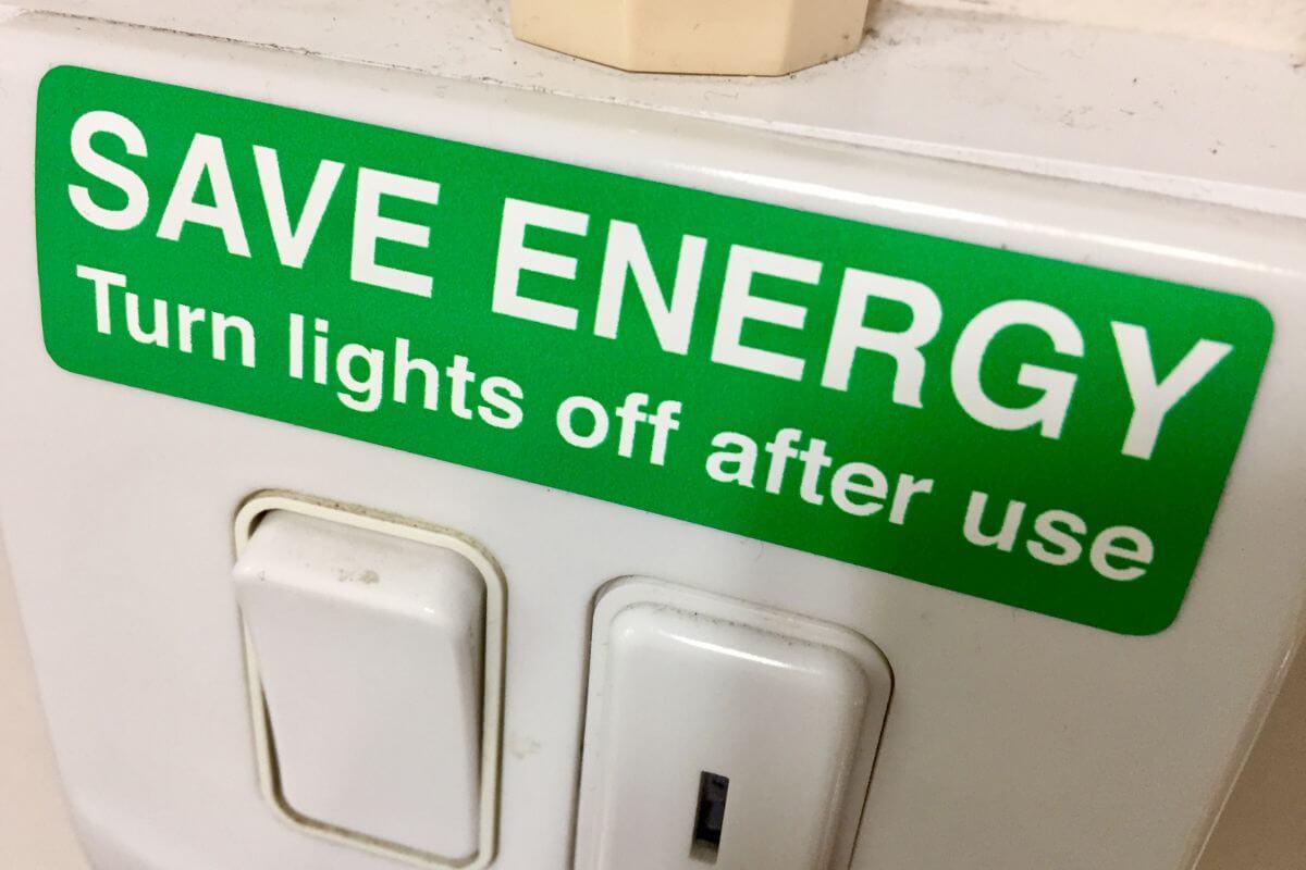 The image tells about a light switch with a green note referring to utilizing energy-saving tips to reduce utility costs and leaving you with more for other needs.