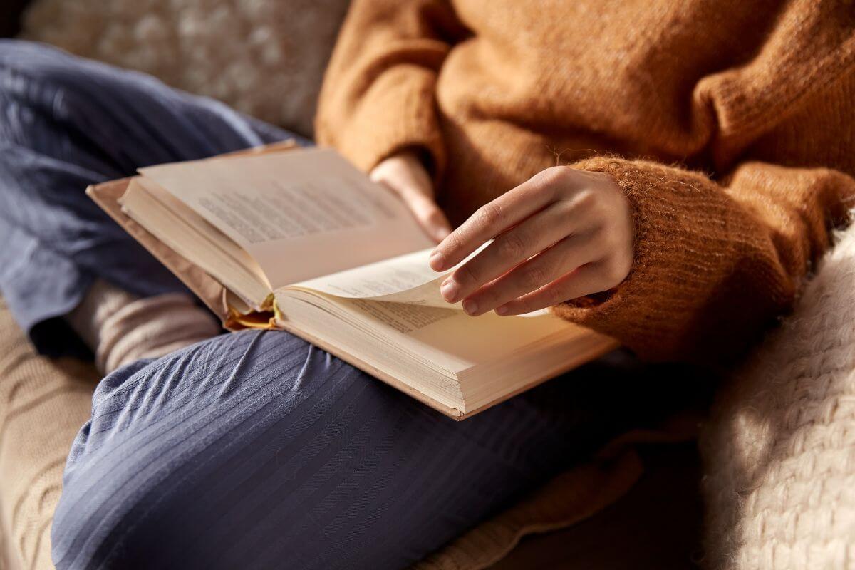 The image shows the girl flipping the book page indicating to start reading to improve your financial knowledge.