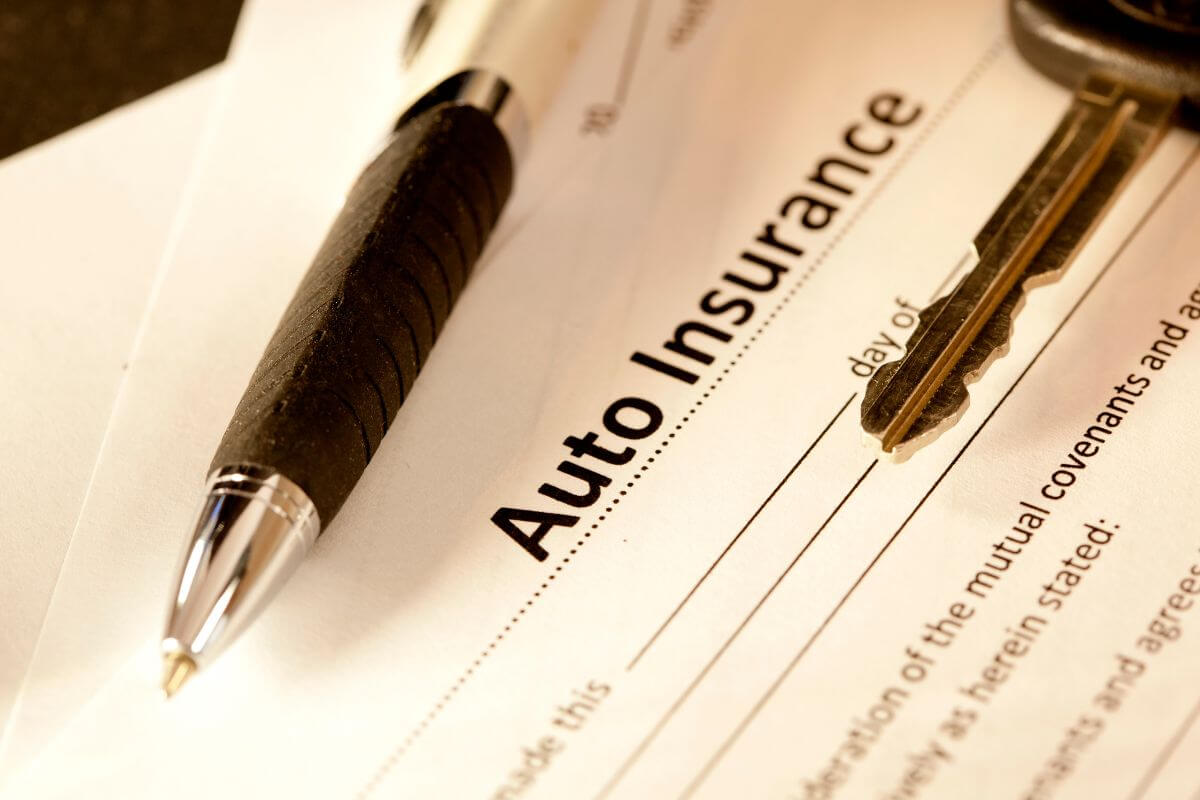 The picture shows a pen, a car key, and a piece of paper with notes indicating to check for discounts on auto insurance for seniors to lower your premiums and save money on car expenses.