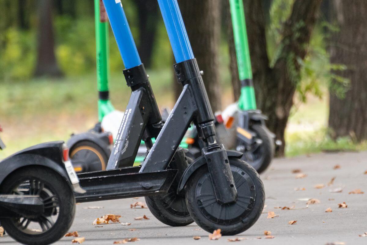 The image shows scooters in the park referring to the offer of scooter rentals in your area to help you earn quick money.
