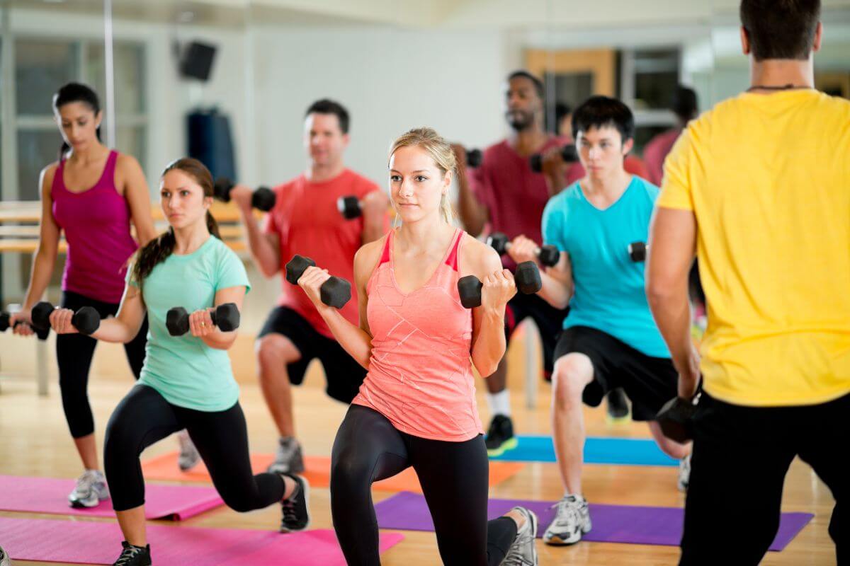 The photo shows a group of people doing an exercise at the gym referring to teaching a local fitness class can be a quick way to make money.