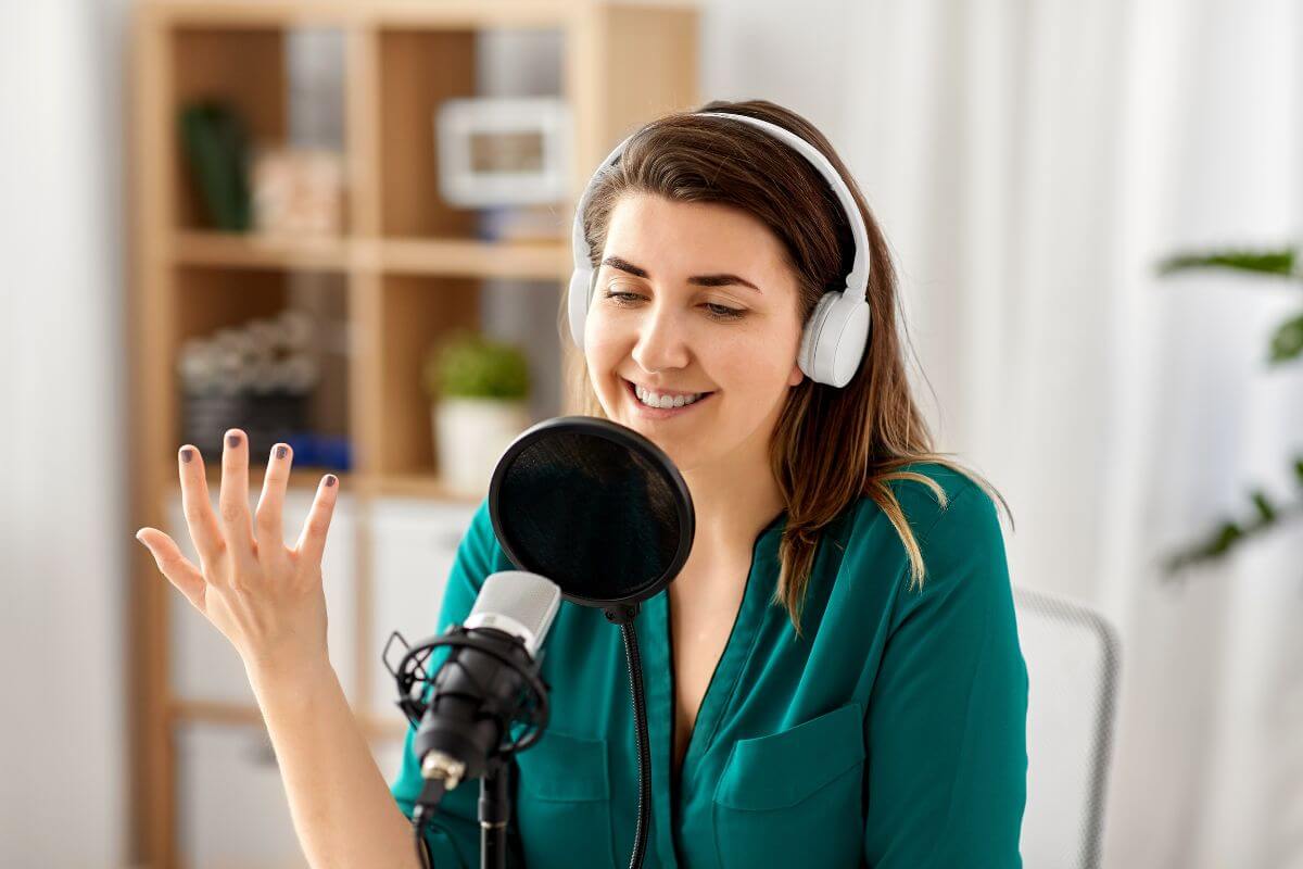 The image shows a girl with a microphone and headset recording at the studio which refers to starting a podcast and monetizing it to earn extra income while sharing your ideas.