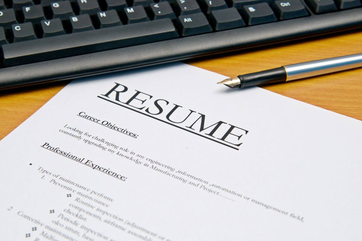 The picture shows a keyboard, a pen, and a piece of paper with notes referring to offering resume writing services to make extra money while others succeed.