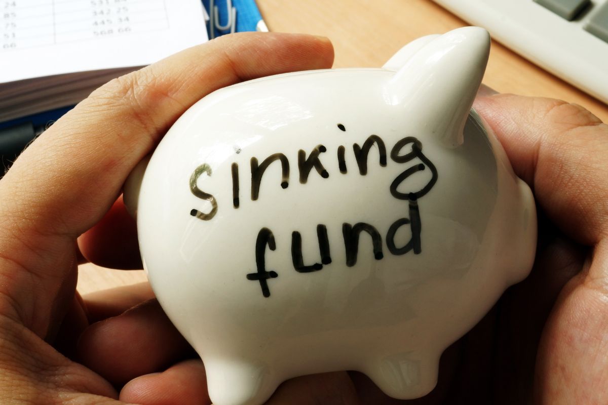 Photo of a man's hand holding a sinking fund savings.