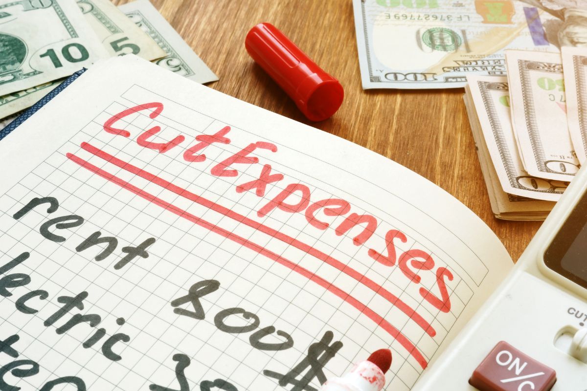 Photo of a notebook with cut expenses wording.