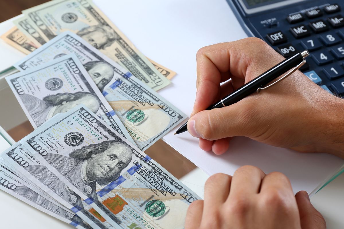 A man's hand setting financial goals.