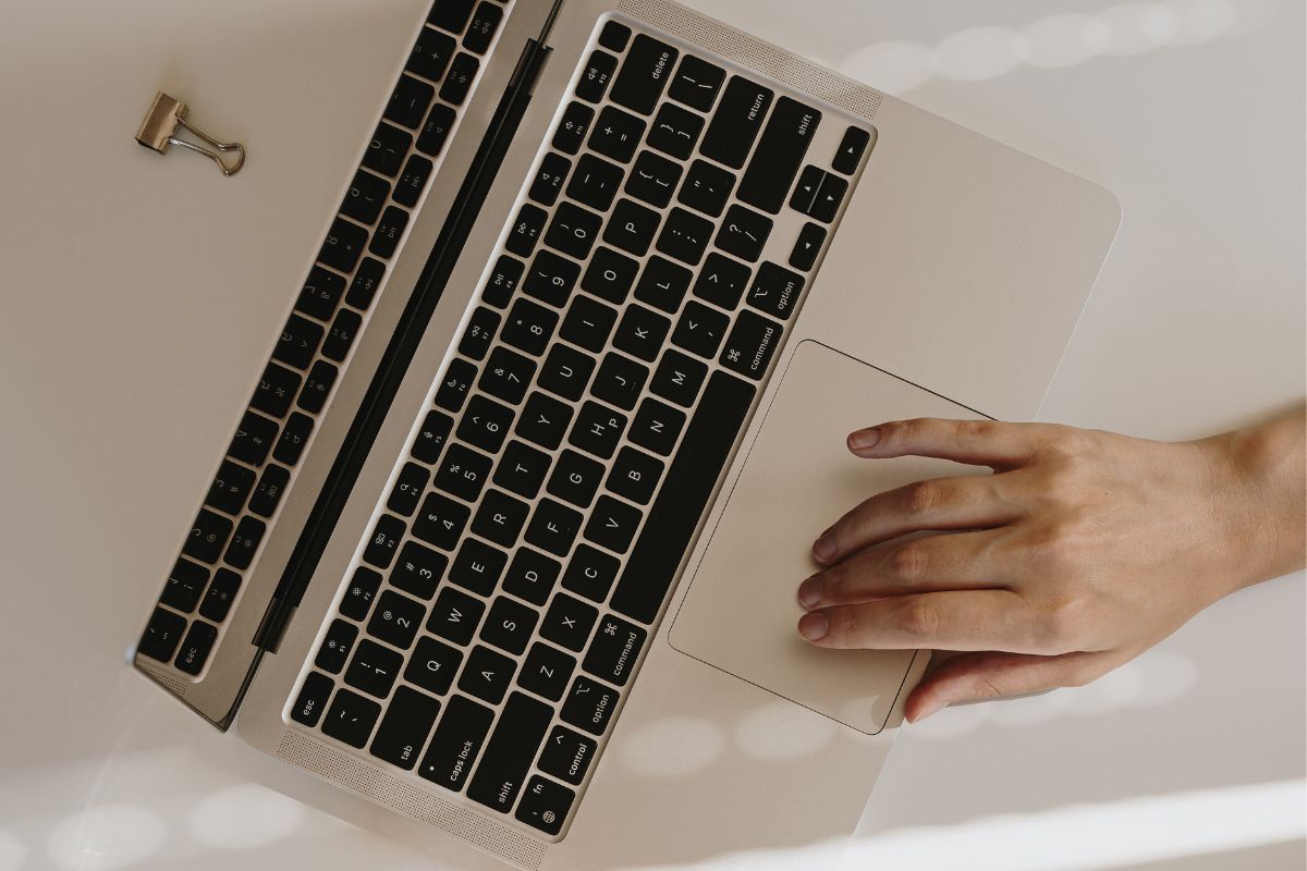 Picture of a woman's hand using a laptop.