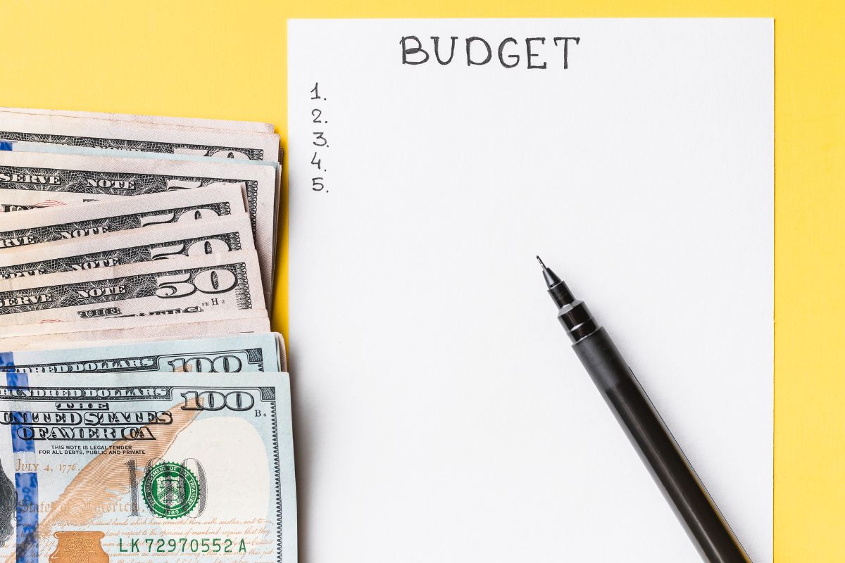 Image of money and paper with budget list.