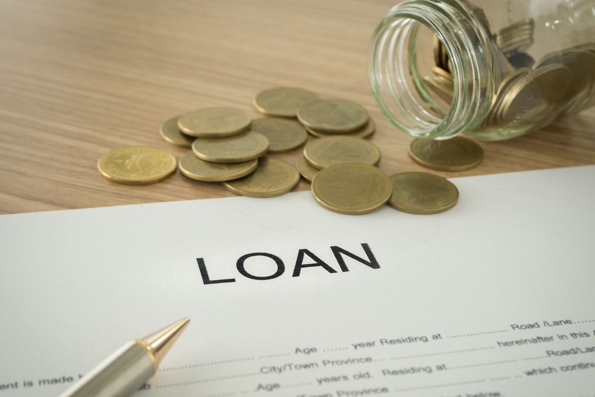 The picture shows a loan paper and coins.