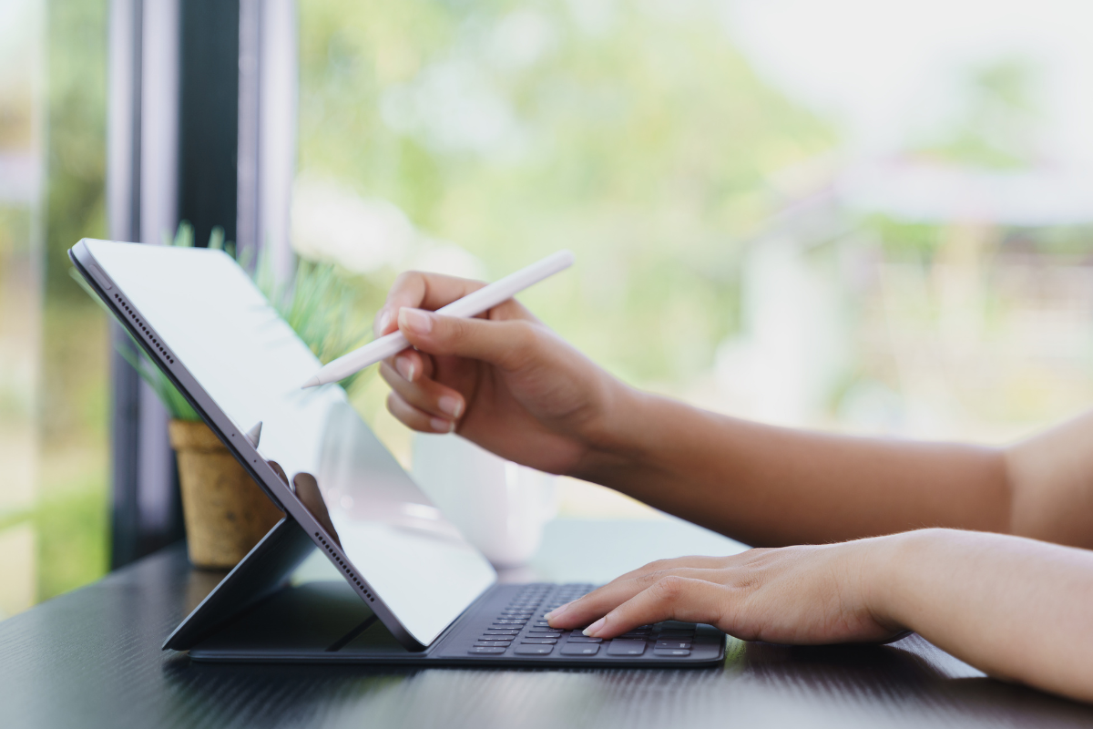 Photo of a woman's hand using a tablet device.