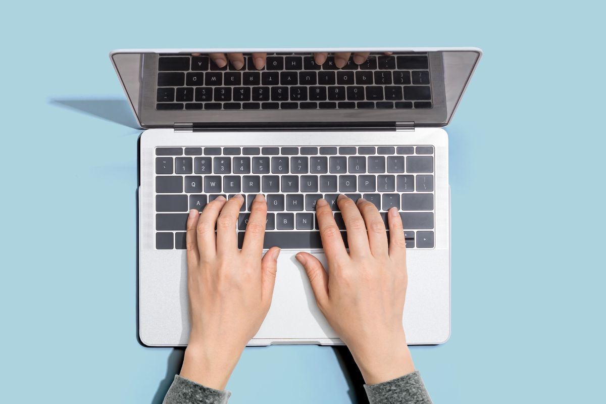 A woman's hand using a laptop.
