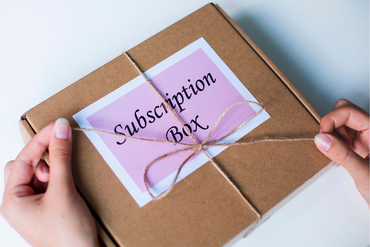 Image of a woman's hand preparing a subscription box. 