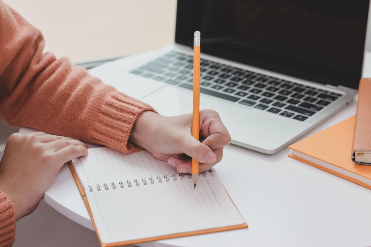 A woman's hand and writing on the notebook.