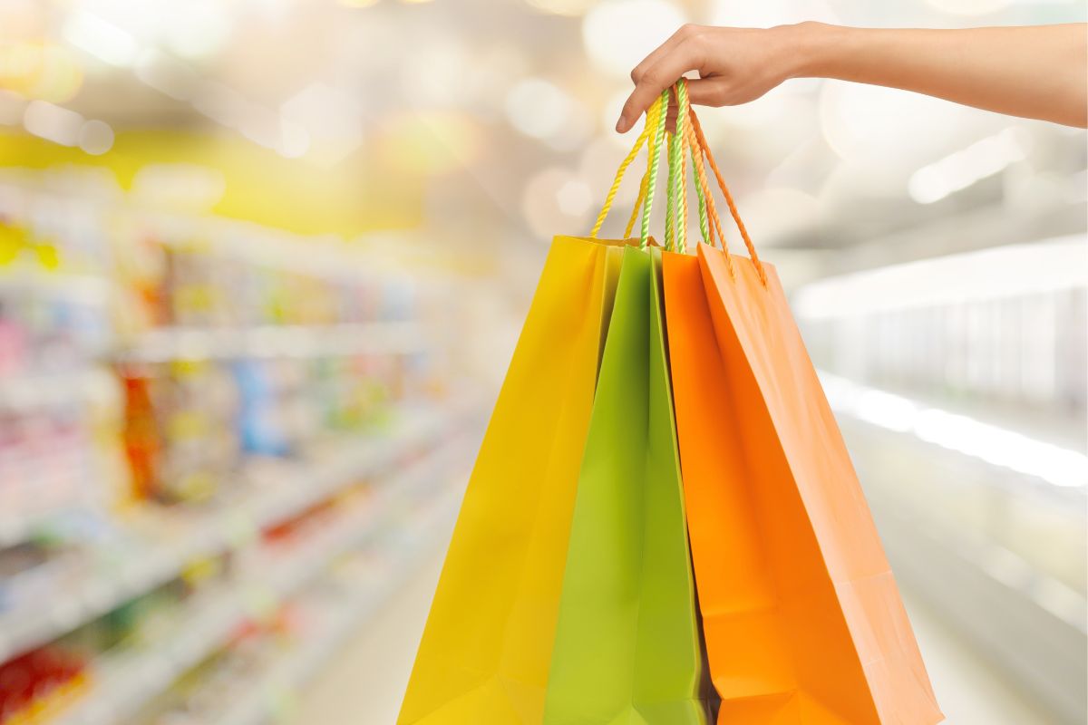 A woman's hand holding shopping bags.