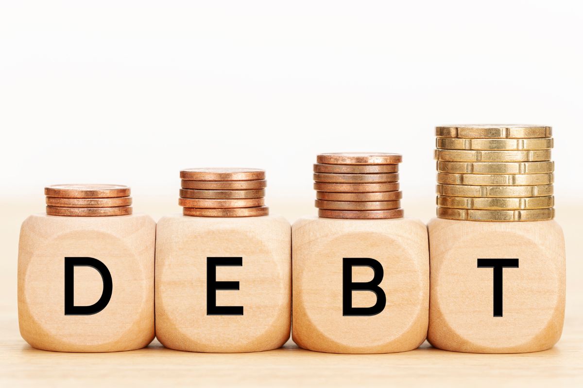 Picture of coins and debt wording.