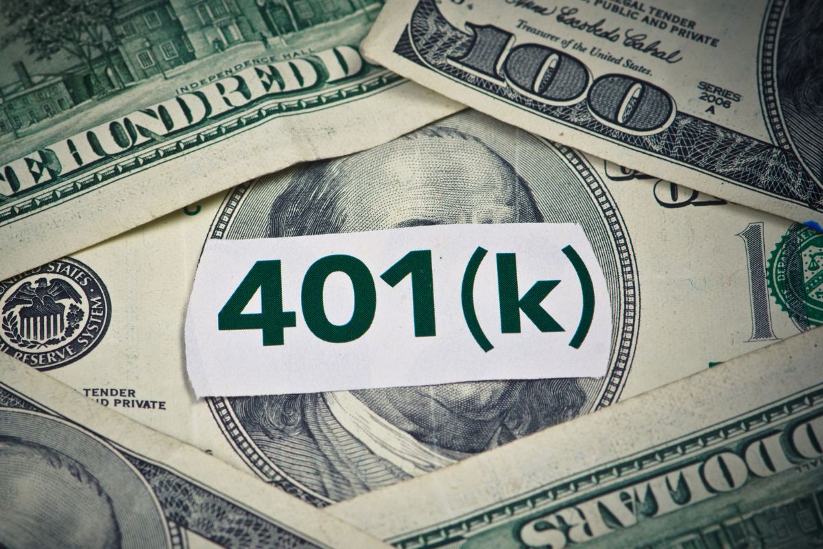 Image of money and a 401k note in a paper.
