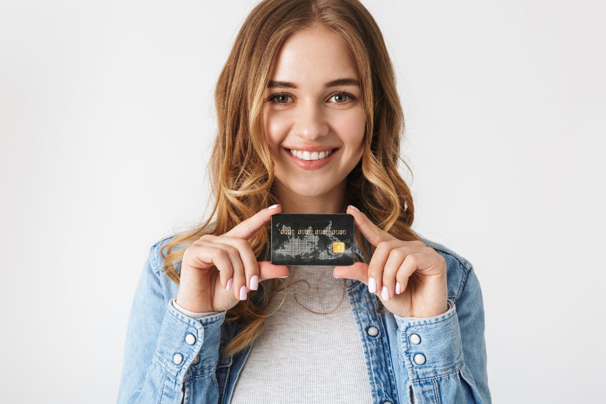 Image of a young lady holding a credit card.