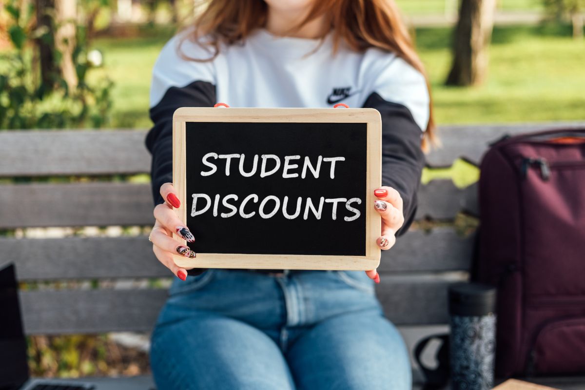 A young lady holding a board with student discount wording.