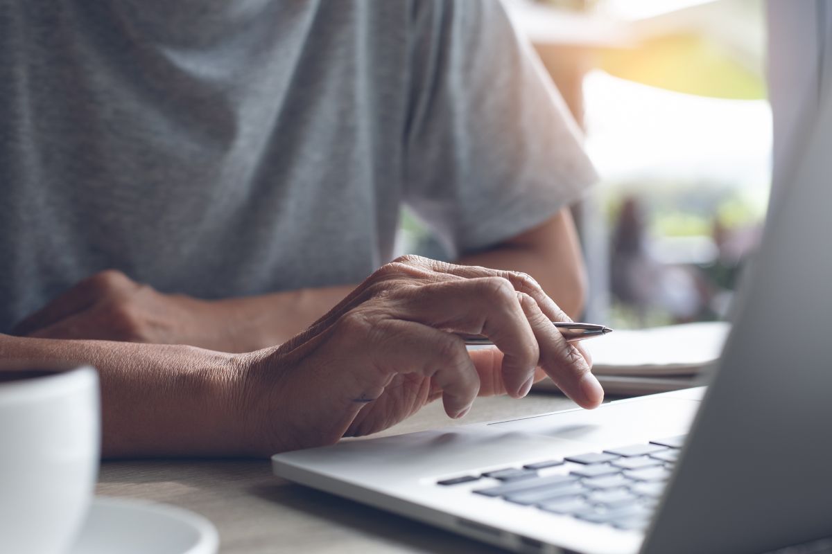 A man's hand using a laptop.