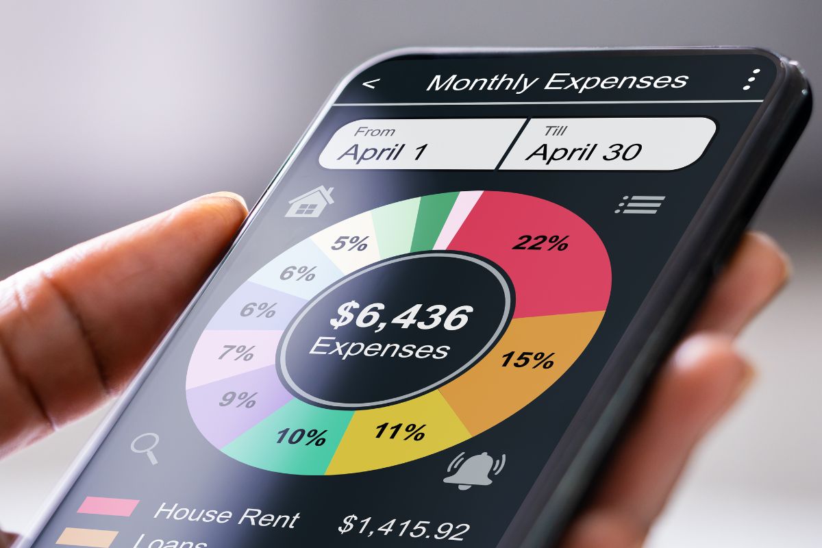 A woman's hand using a spending tracker app.