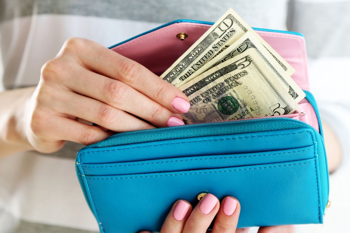 Image of a woman putting her wallet in her wallet.