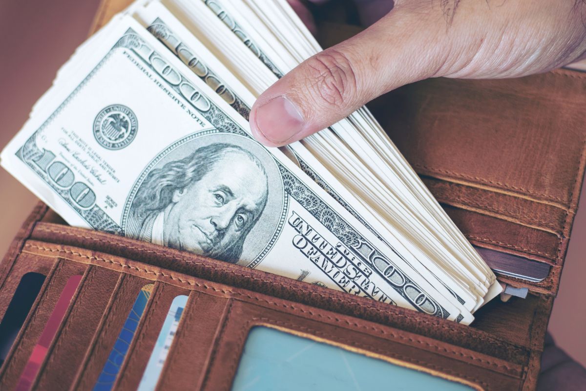 The picture shows a man's wallet with money.