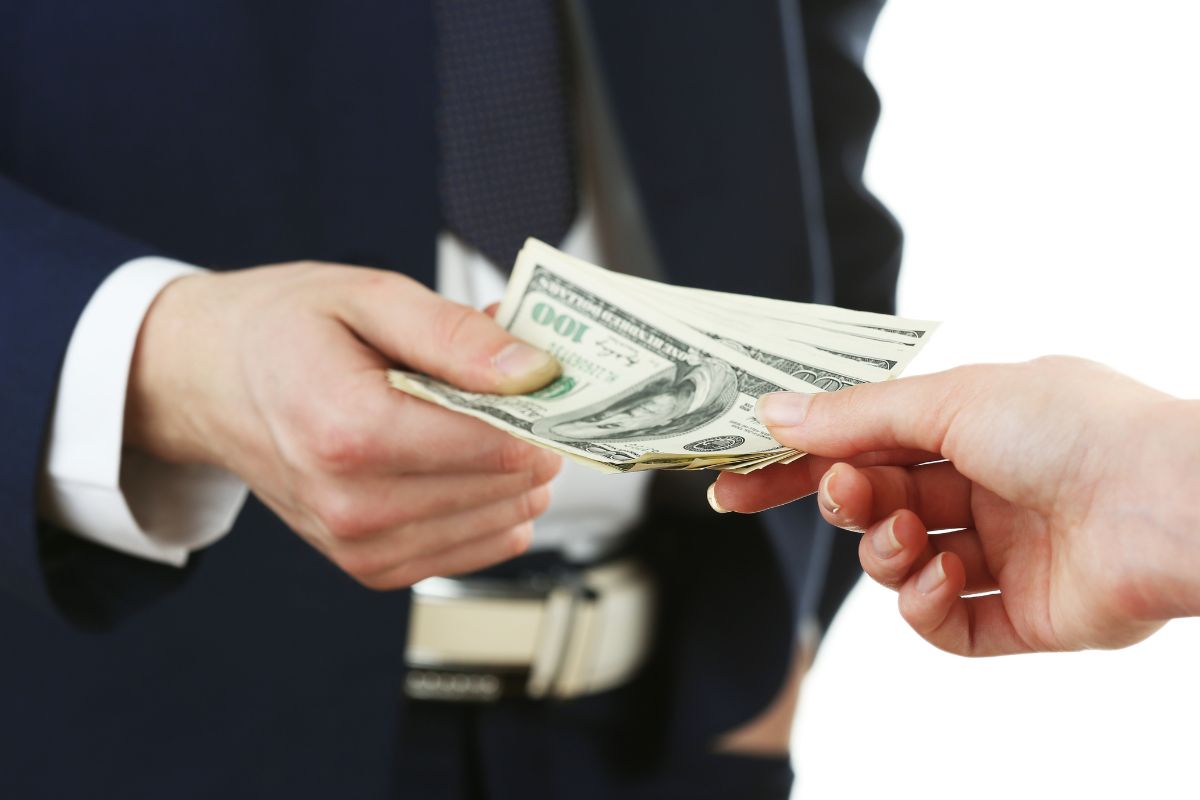 Picture of a man's hand paying debt.