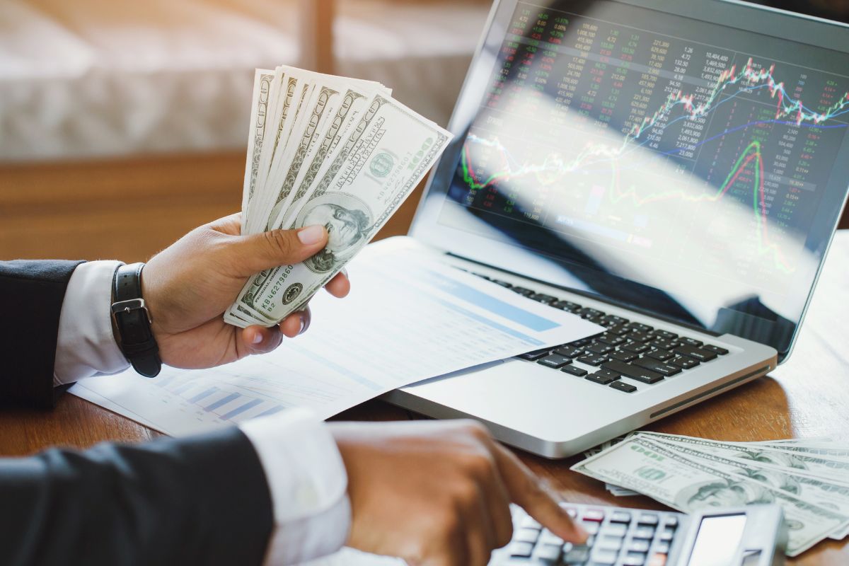 Photo of a man's hand calculating his investment money.
