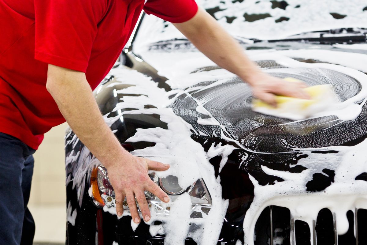 Image of a man washing a car.