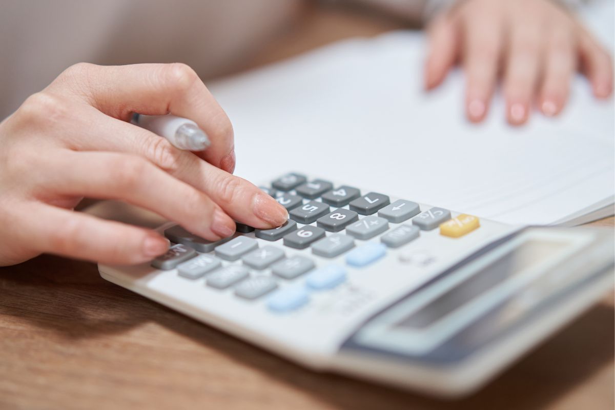 The picture shows a woman's hand reviewing his budget.