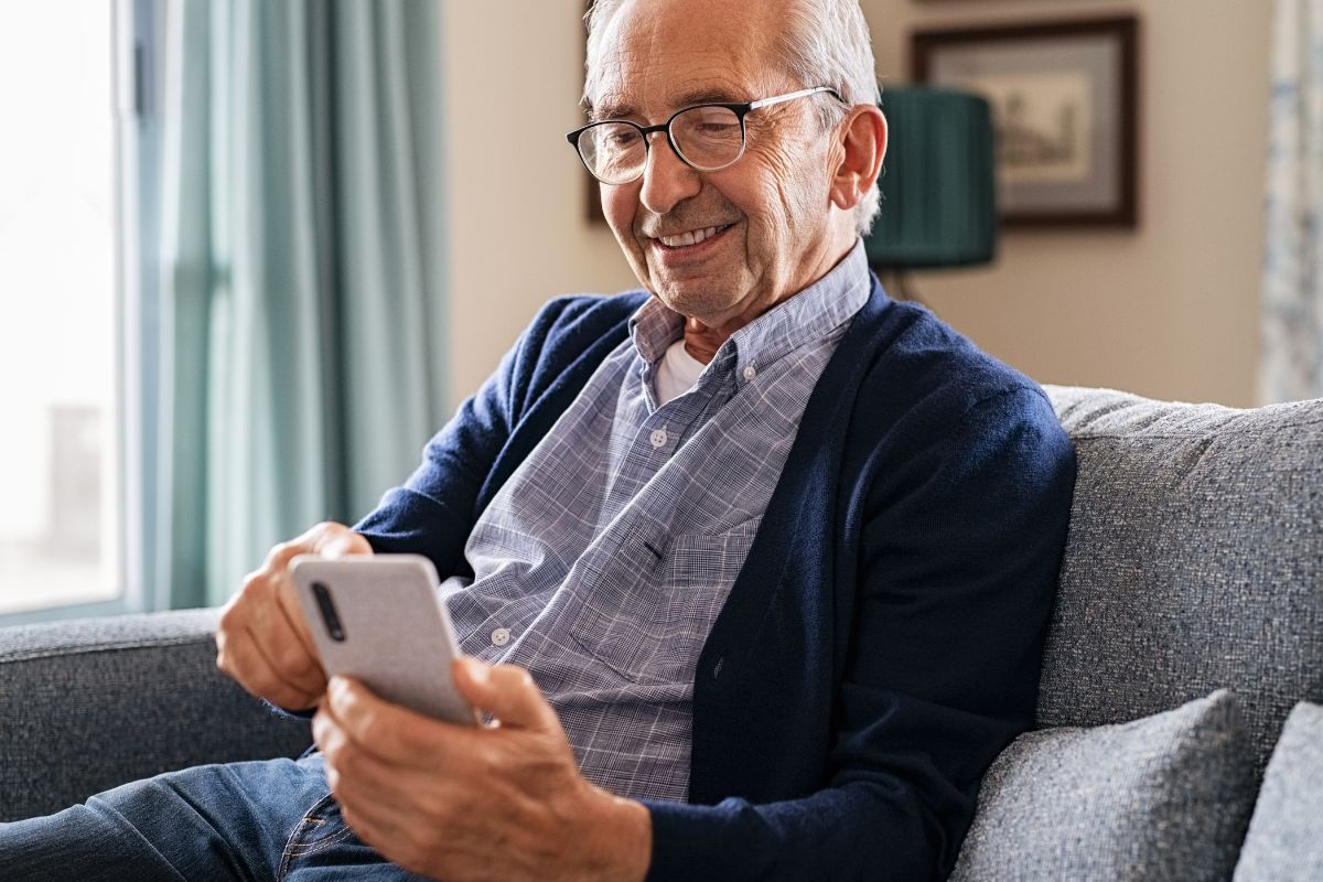 A senior man using a phone.