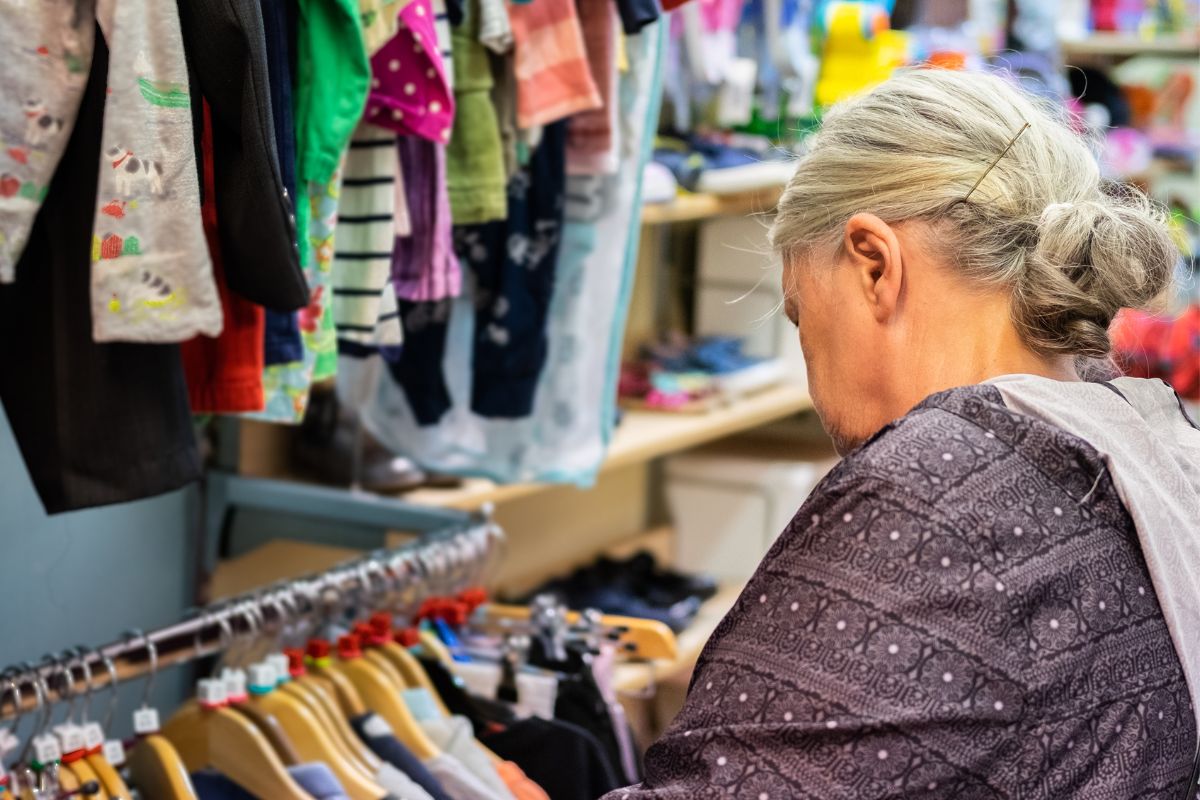 A senior woman shopping for secondhand clothes.