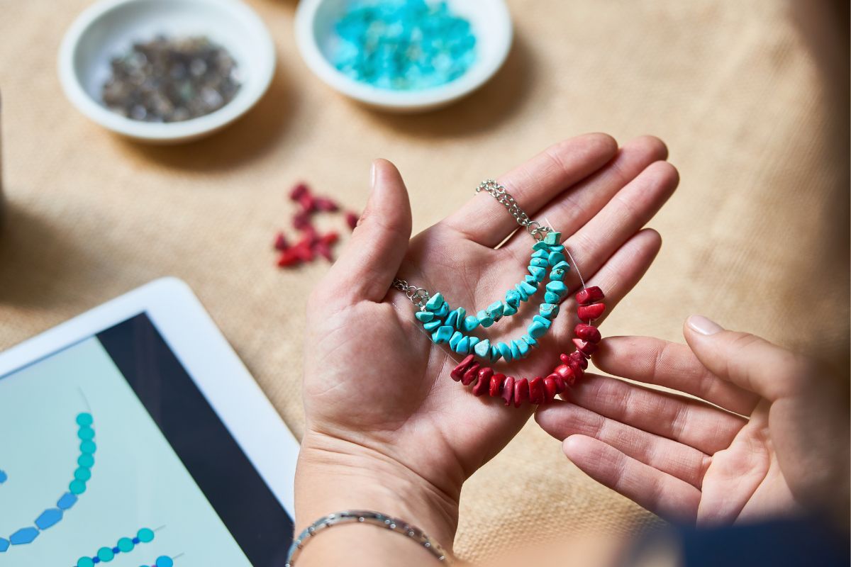 A woman's hand making a handmade necklace.