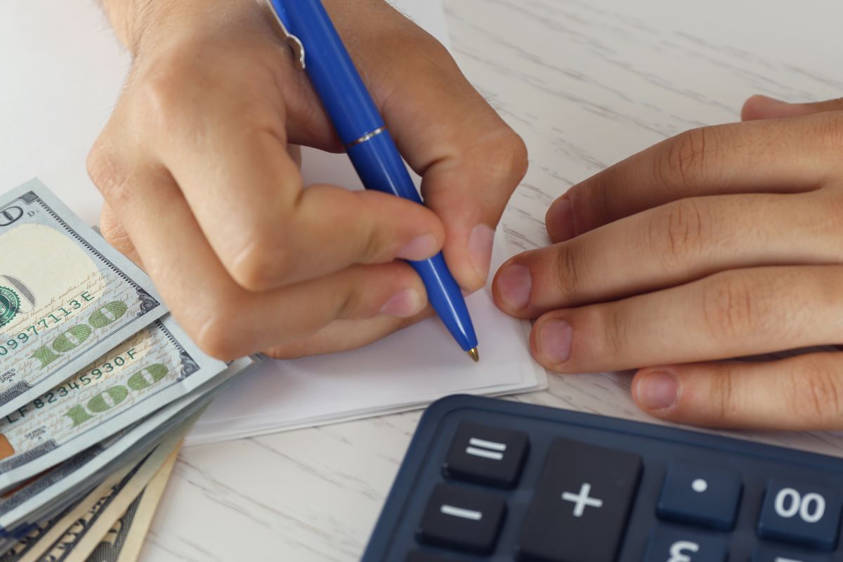 Photo of a man's hand creating a budget.
