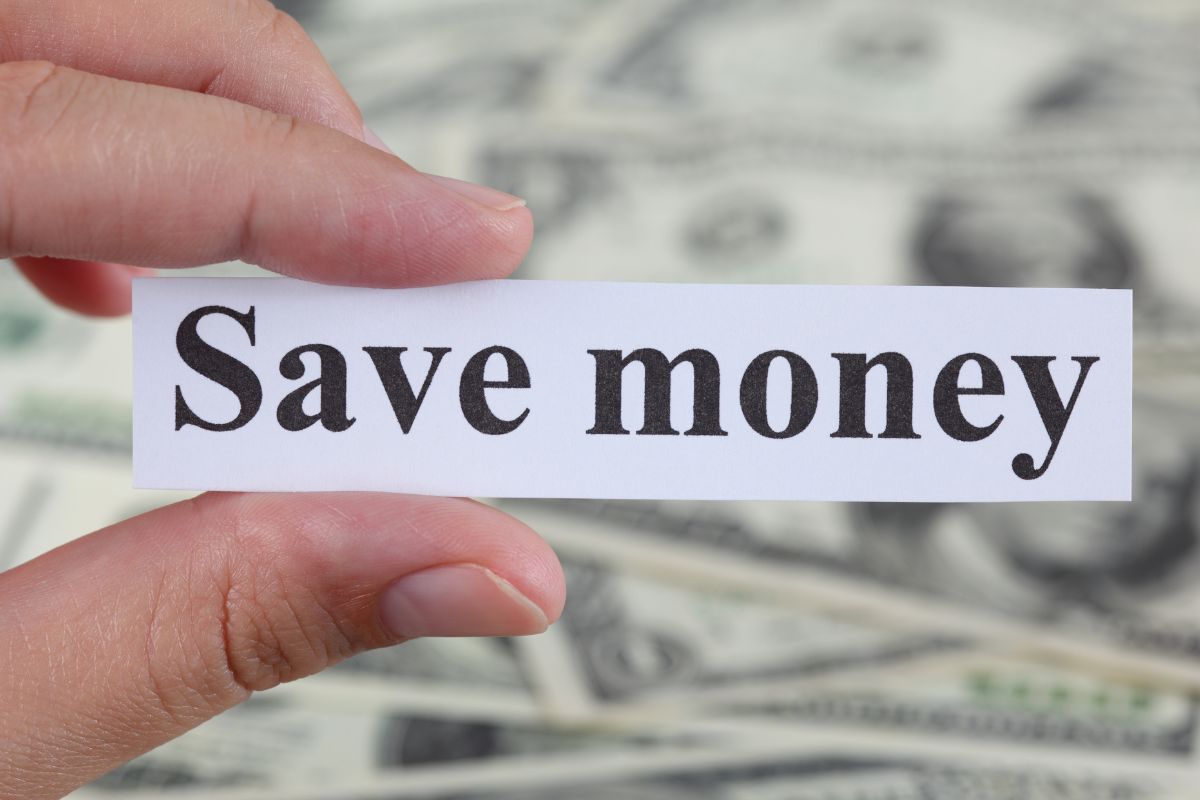 Image of a woman's hand holding a paper with save money wording.