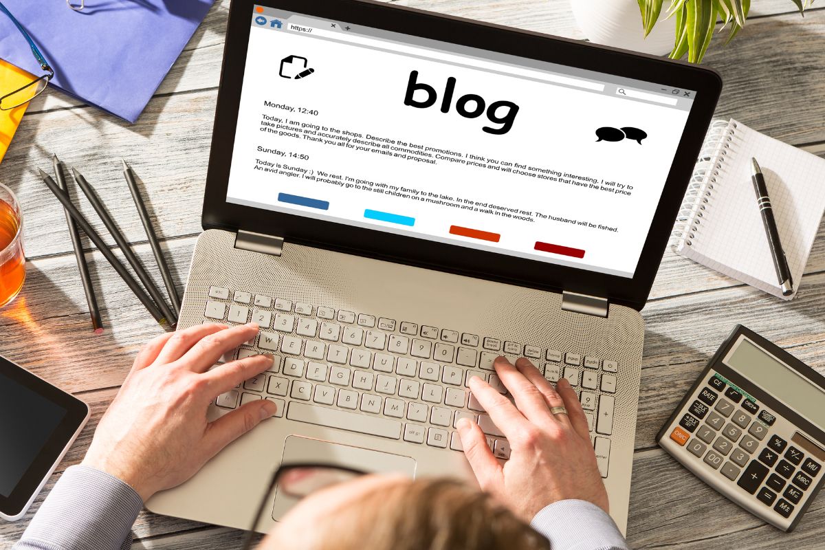 Picture of a man's hand using a laptop with a blog.