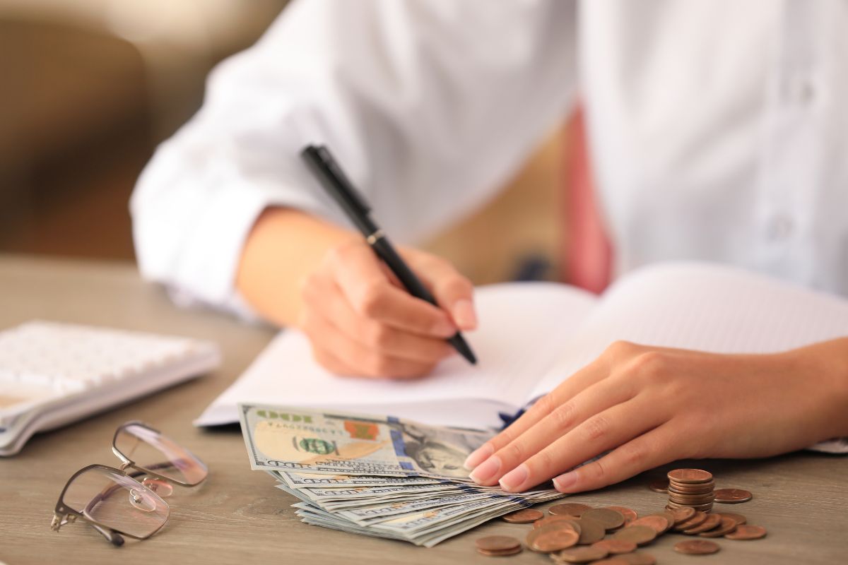 Picture of a woman's hand reassessing her financial goals.
