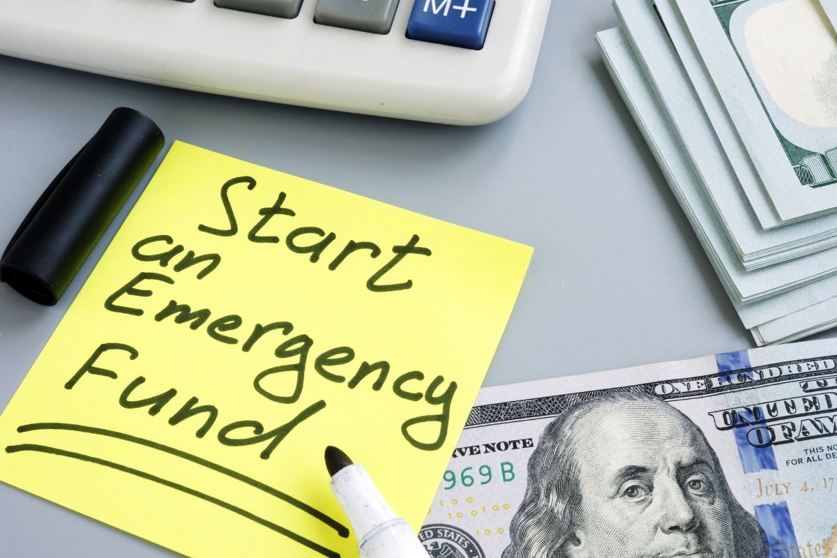 Picture of money and paper with emergency fund wording.