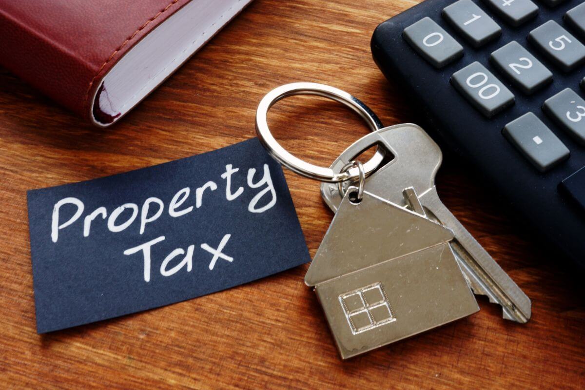 The photo of a notebook, a calculator, a key with a house keychain, and a black paper with notes refers to many retirees who qualify for property tax deductions and use that extra money for other priorities.