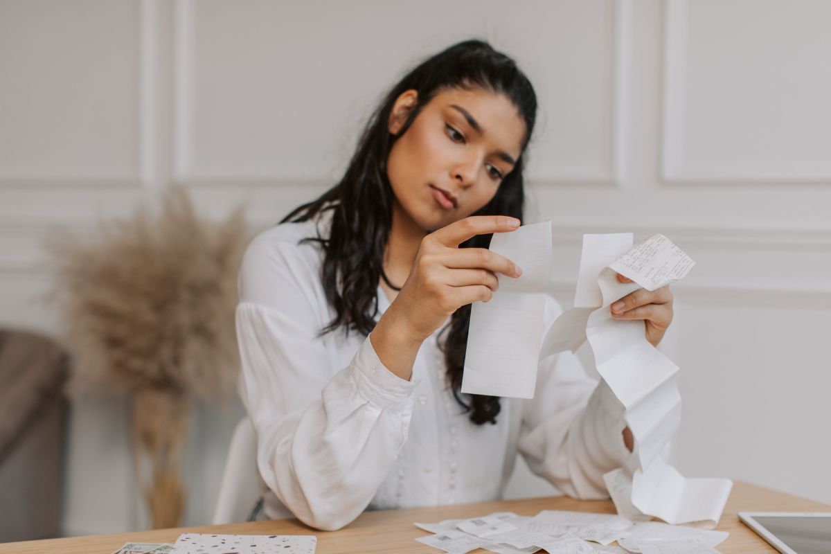The picture shows a woman tracking her spending.