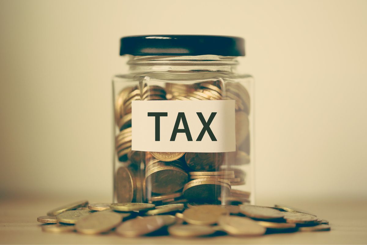 The photo shows a jar with coins and tax wording.