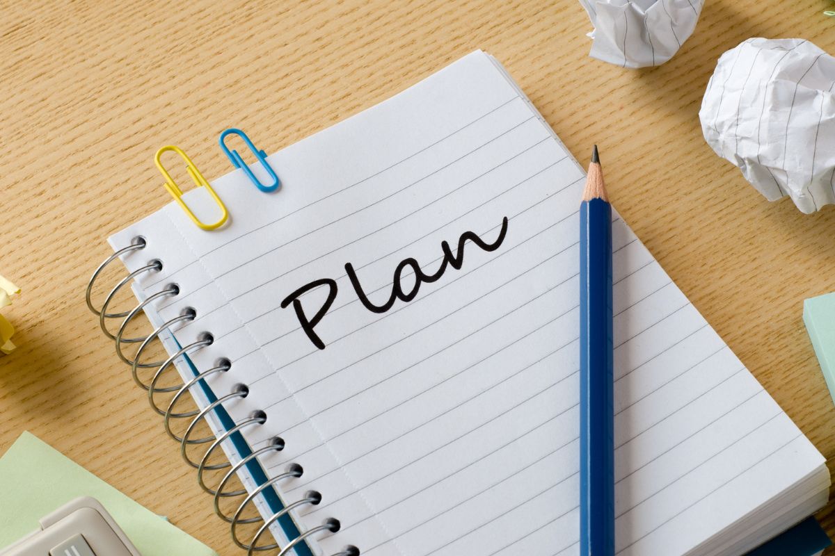 Photo of a pen and a notebook with plain wording.