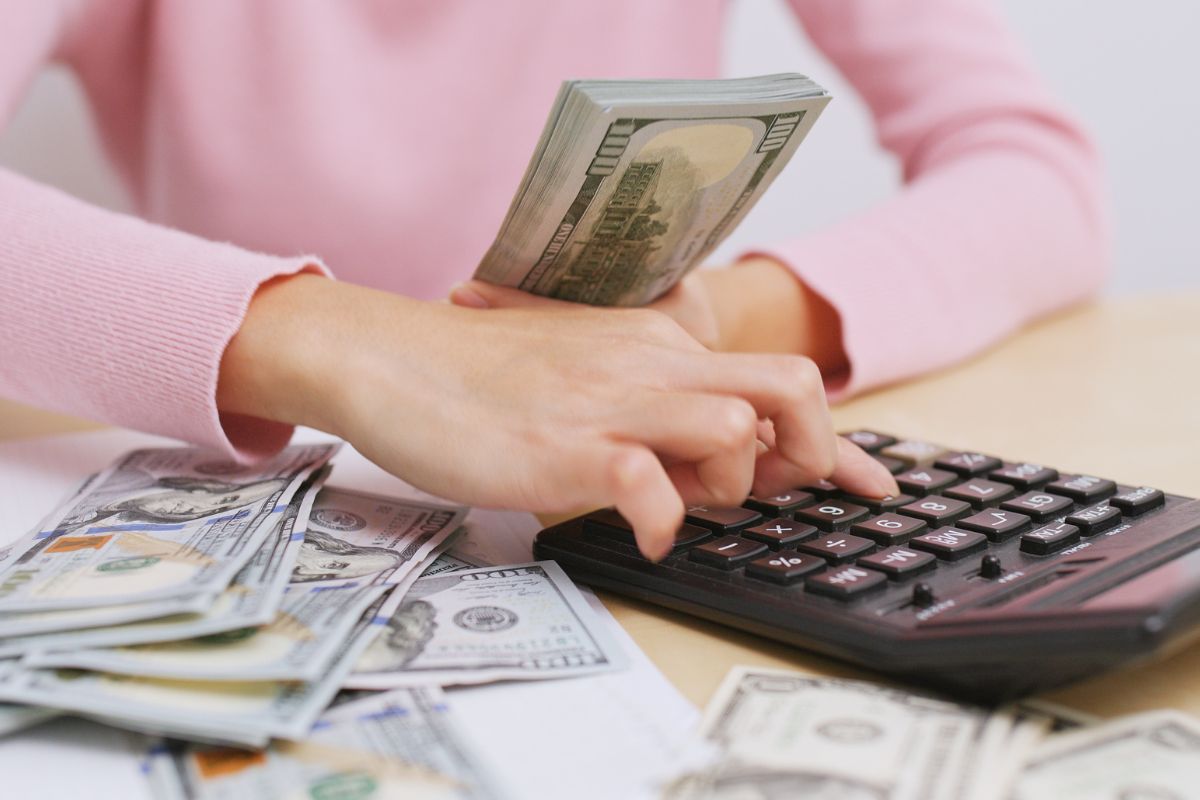 Picture of a woman's hand calcualting her money.