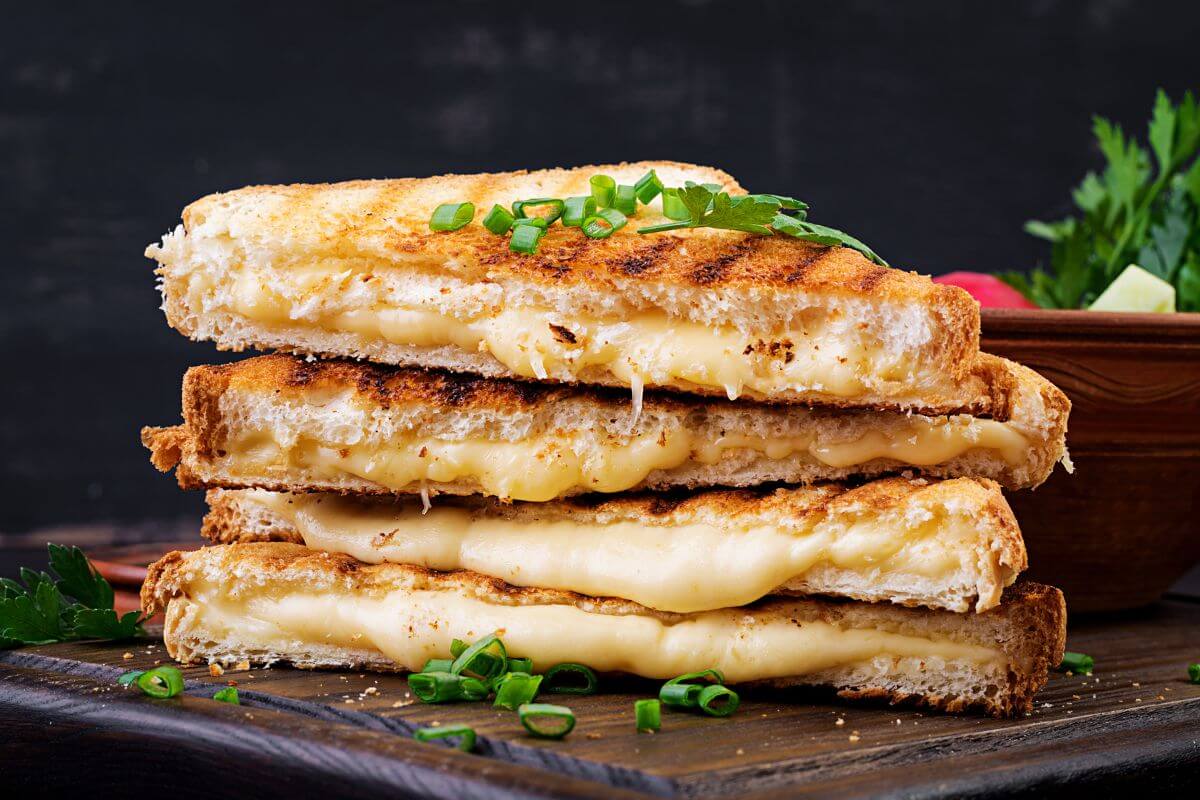 The picture tells about grilled cheese sandwiches, which are comfort foods that's simple to make and affordable and wont break a bank.