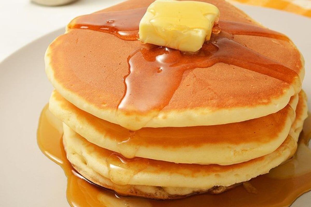 The image shows pancakes with syrup and butter at the top for a delicious treat that's kind to your wallet.