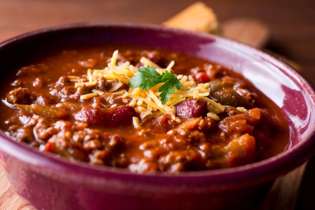 The image tells about a bowl with chili, beans, and cheese is a hearty and budget-friendly meal that's perfect for stretching ingredients.
