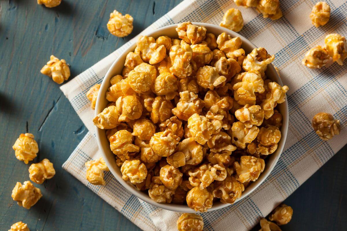 The image tells about a bowl of caramelized popcorn on the table which is a perfect choice for frugal snacking at home while staying under budget.
