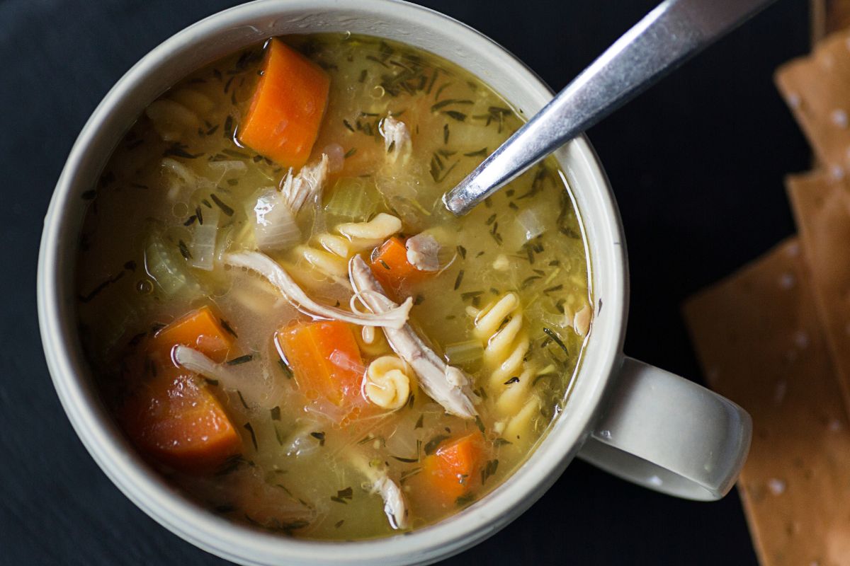 Picture of soup in a cup with chicken and vegetables.